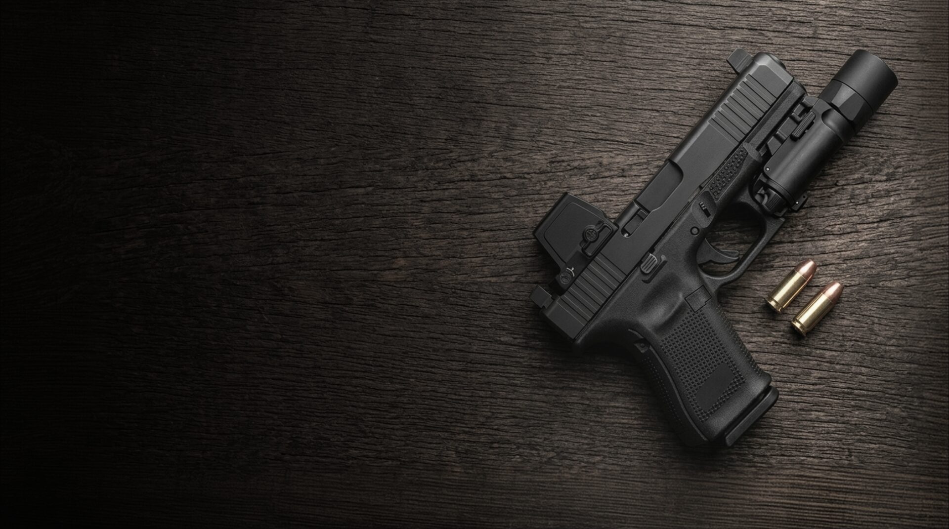 Glock 19 Gen 6 pistol with red dot sight, weapon light and 9mm rounds on dark timber